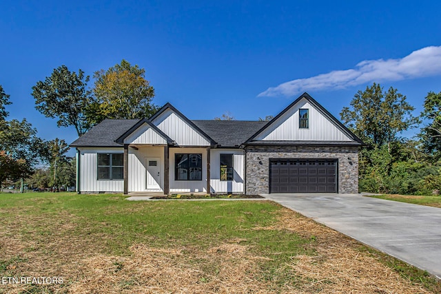 modern inspired farmhouse featuring a porch, a garage, and a front lawn