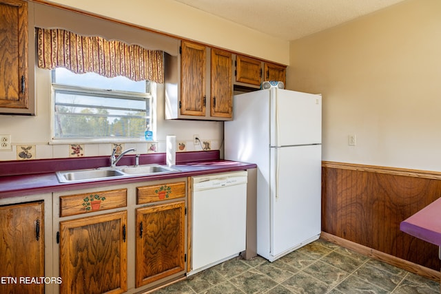 kitchen with a textured ceiling, white appliances, and sink