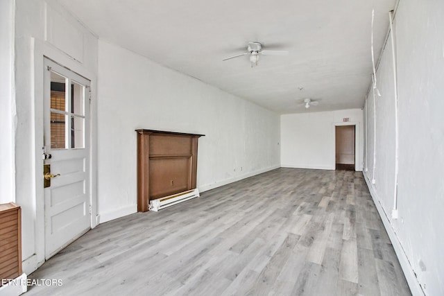 empty room with baseboard heating, ceiling fan, and light hardwood / wood-style flooring