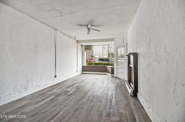 spare room featuring ceiling fan, a wall mounted air conditioner, and hardwood / wood-style flooring