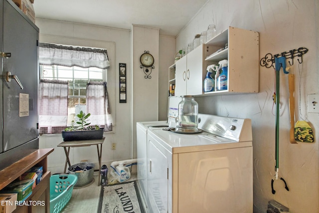 washroom featuring cabinets and independent washer and dryer