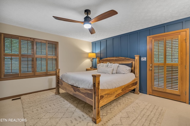 carpeted bedroom with multiple windows, ceiling fan, and a textured ceiling