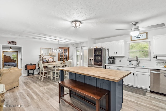 kitchen featuring white cabinets, ceiling fan, stainless steel appliances, and sink