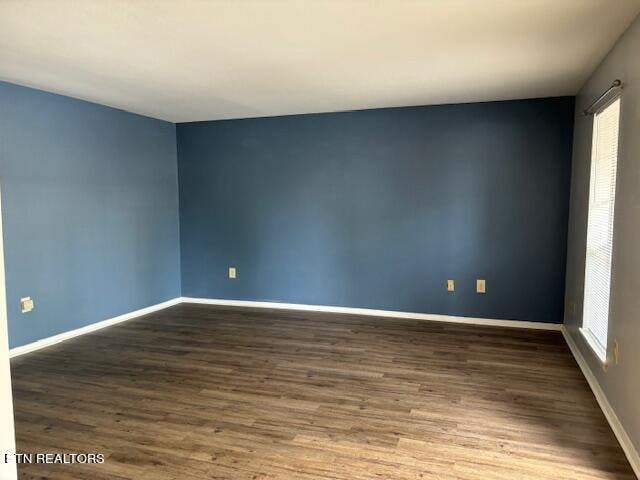 empty room featuring dark hardwood / wood-style flooring