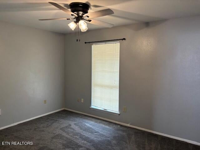 unfurnished room with ceiling fan and dark colored carpet