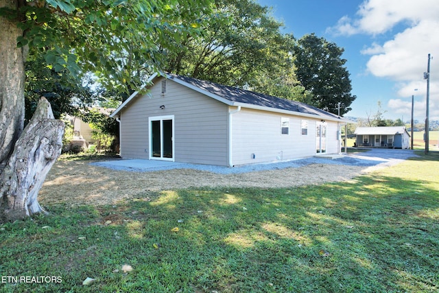 rear view of house featuring a patio area and a yard