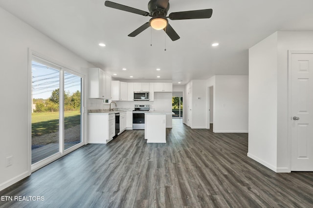 kitchen with appliances with stainless steel finishes, a kitchen island, dark hardwood / wood-style flooring, white cabinetry, and ceiling fan