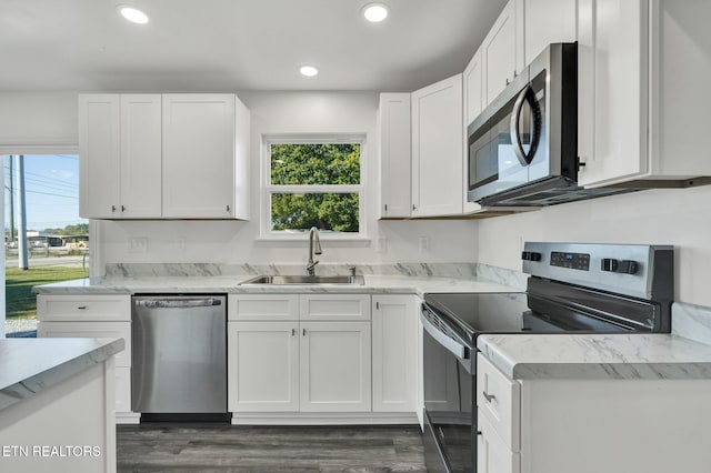 kitchen featuring appliances with stainless steel finishes, white cabinetry, sink, and dark wood-type flooring