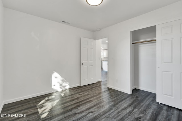 unfurnished bedroom featuring a closet and dark hardwood / wood-style floors