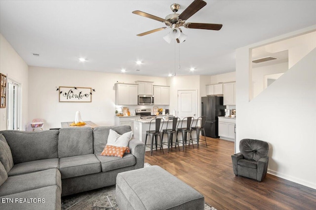 living room with ceiling fan and dark wood-type flooring