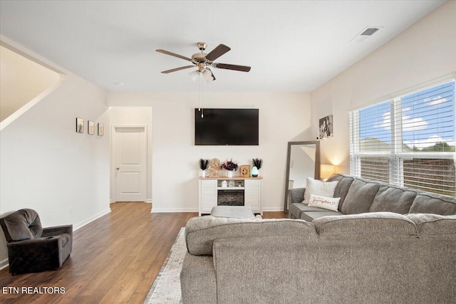 living room with ceiling fan, hardwood / wood-style flooring, and a fireplace