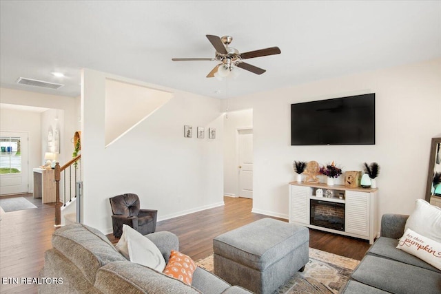 living room with ceiling fan and dark wood-type flooring