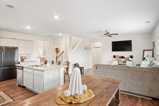 dining space with ceiling fan, sink, and dark hardwood / wood-style flooring