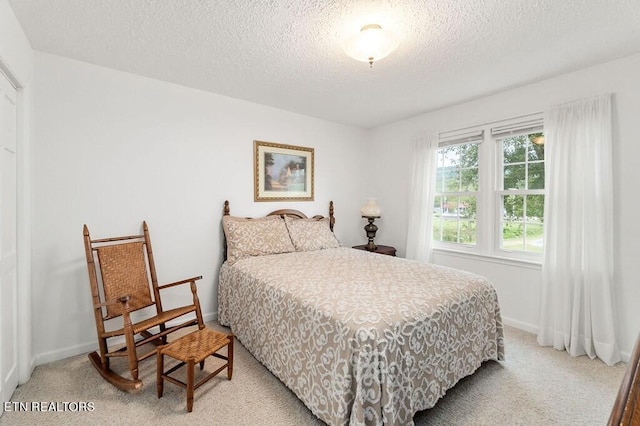 bedroom featuring a textured ceiling and carpet flooring