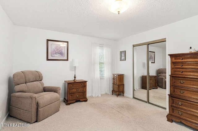 living area featuring a textured ceiling and light colored carpet