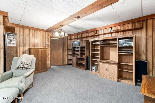 interior space featuring wooden walls, an inviting chandelier, and light colored carpet