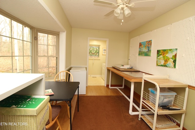 dining room featuring baseboards, a textured ceiling, wood finished floors, and a ceiling fan