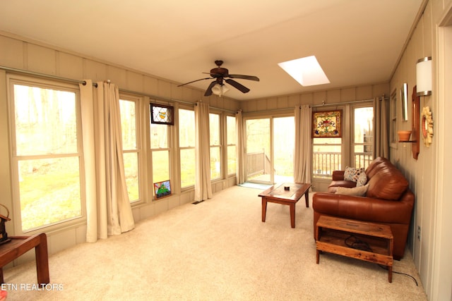 sunroom / solarium featuring ceiling fan, a skylight, and a wealth of natural light