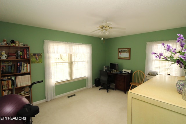 office area with a ceiling fan, baseboards, light colored carpet, and visible vents