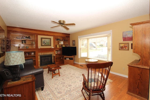 living area with light wood finished floors, baseboards, and a ceiling fan