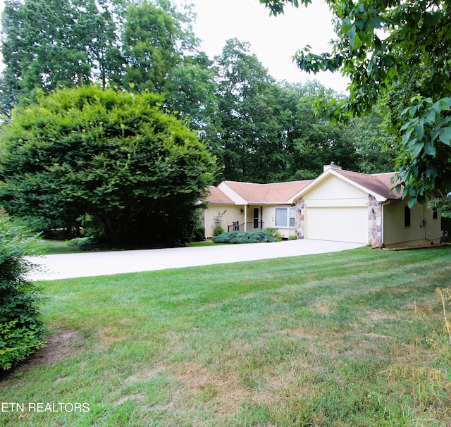 view of front of home featuring an attached garage, stone siding, driveway, a front yard, and a chimney