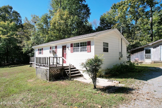 view of front of property with a wooden deck, cooling unit, and a front yard