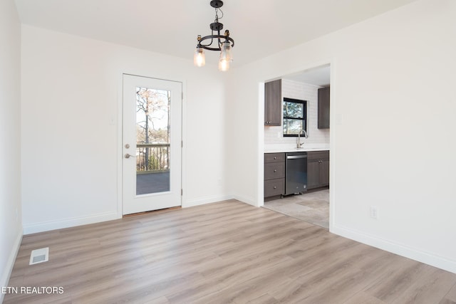 interior space featuring sink, light hardwood / wood-style floors, and a chandelier