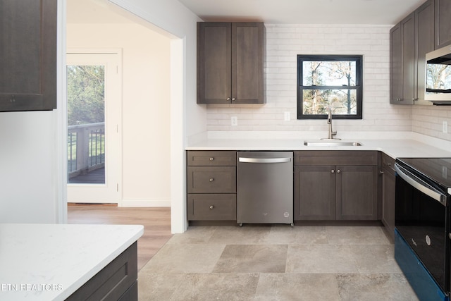 kitchen featuring dark brown cabinetry, sink, decorative backsplash, and stainless steel appliances