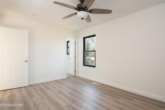 empty room with ceiling fan and light hardwood / wood-style floors