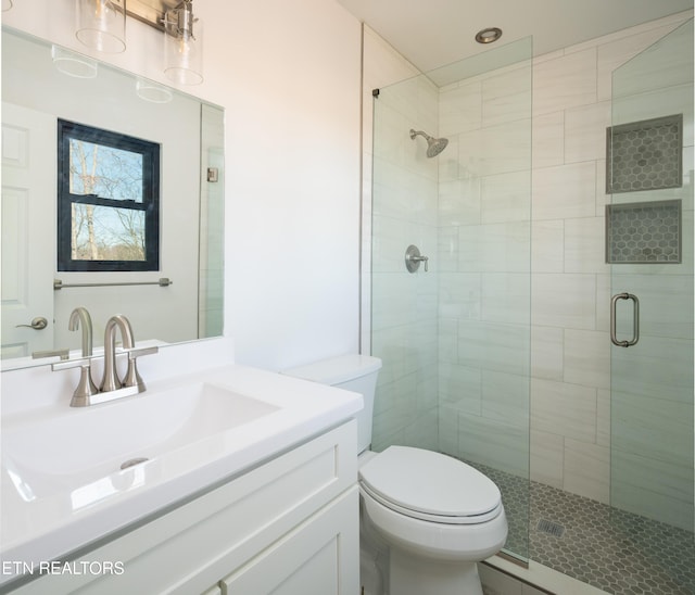 bathroom with toilet, vanity, and walk in shower