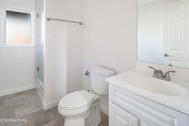 bathroom featuring vanity, toilet, and a shower with door