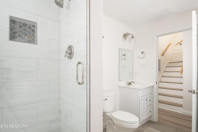 bathroom with vanity, a shower with door, and toilet