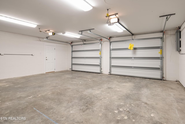 garage with a garage door opener and electric panel