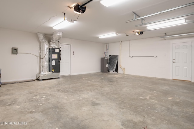 garage featuring heating unit, a garage door opener, and electric water heater