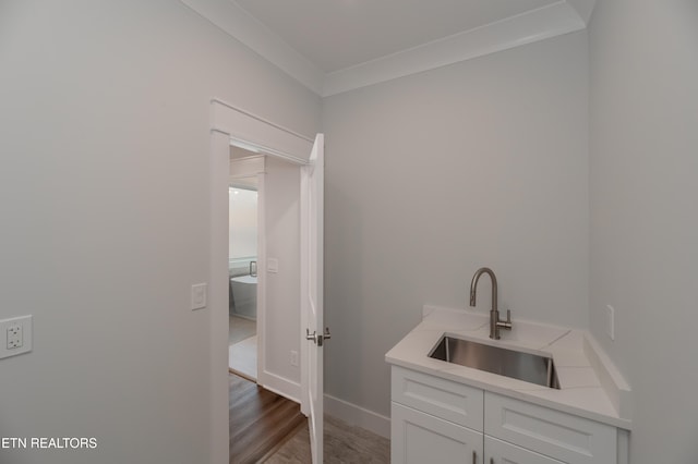 bathroom featuring ornamental molding, vanity, baseboards, and wood finished floors