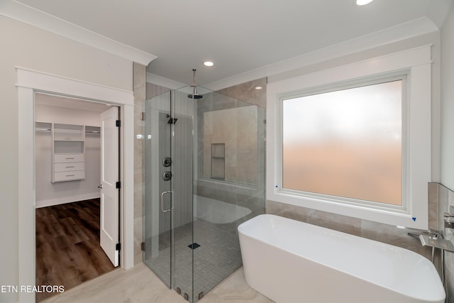 full bath featuring recessed lighting, wood finished floors, a spacious closet, a soaking tub, and a shower stall