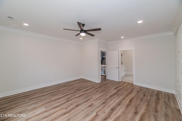 unfurnished room with ornamental molding, recessed lighting, light wood-style floors, and baseboards