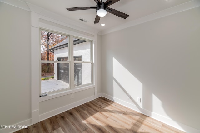 empty room with baseboards, visible vents, crown molding, light wood-type flooring, and recessed lighting