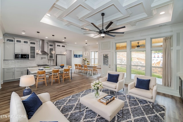 living room with ornamental molding, dark wood-type flooring, coffered ceiling, and beam ceiling