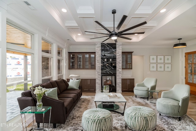 living room with crown molding, light wood finished floors, visible vents, coffered ceiling, and beamed ceiling