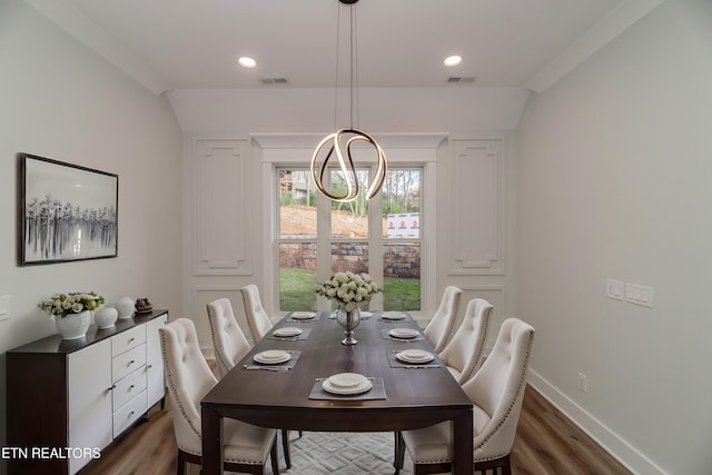 dining space featuring an inviting chandelier, visible vents, baseboards, and wood finished floors