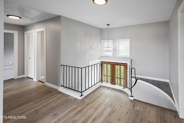 stairs featuring hardwood / wood-style floors and a chandelier