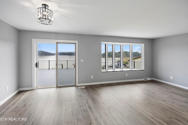 unfurnished room featuring light hardwood / wood-style flooring and an inviting chandelier