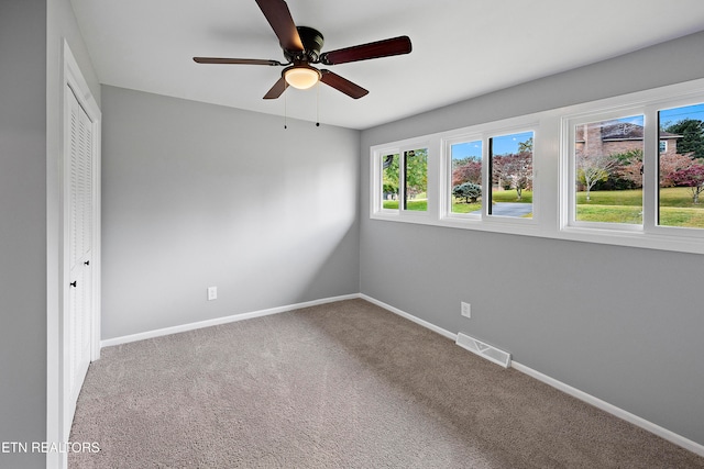 unfurnished bedroom with a closet, carpet floors, and ceiling fan