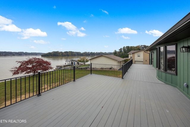 deck with a yard and a water view