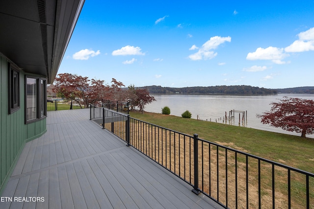 wooden terrace with a yard and a water view