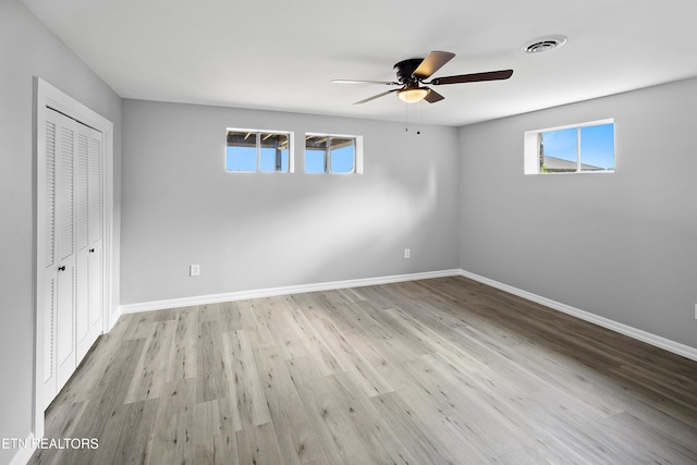 unfurnished bedroom featuring a closet, light wood-type flooring, and ceiling fan