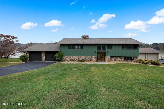 view of front of home with a front yard and a garage