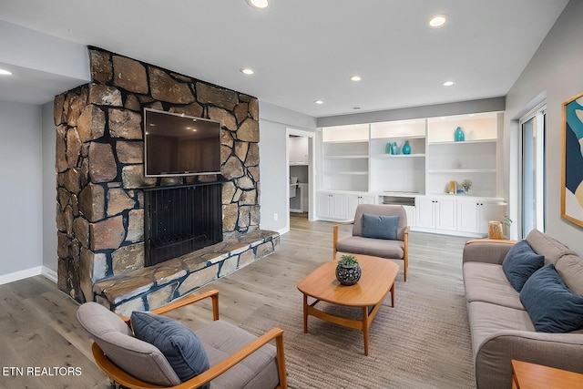 living room with a fireplace and light wood-type flooring