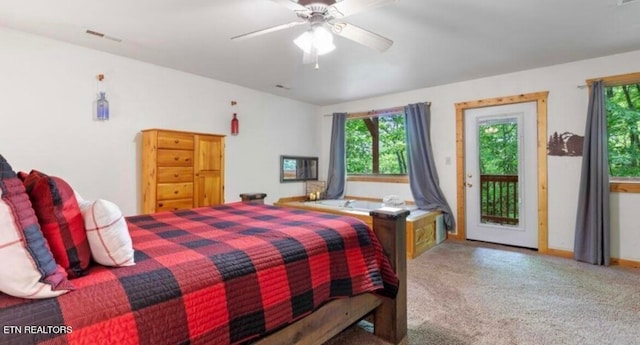 carpeted bedroom featuring multiple windows, ceiling fan, and access to exterior